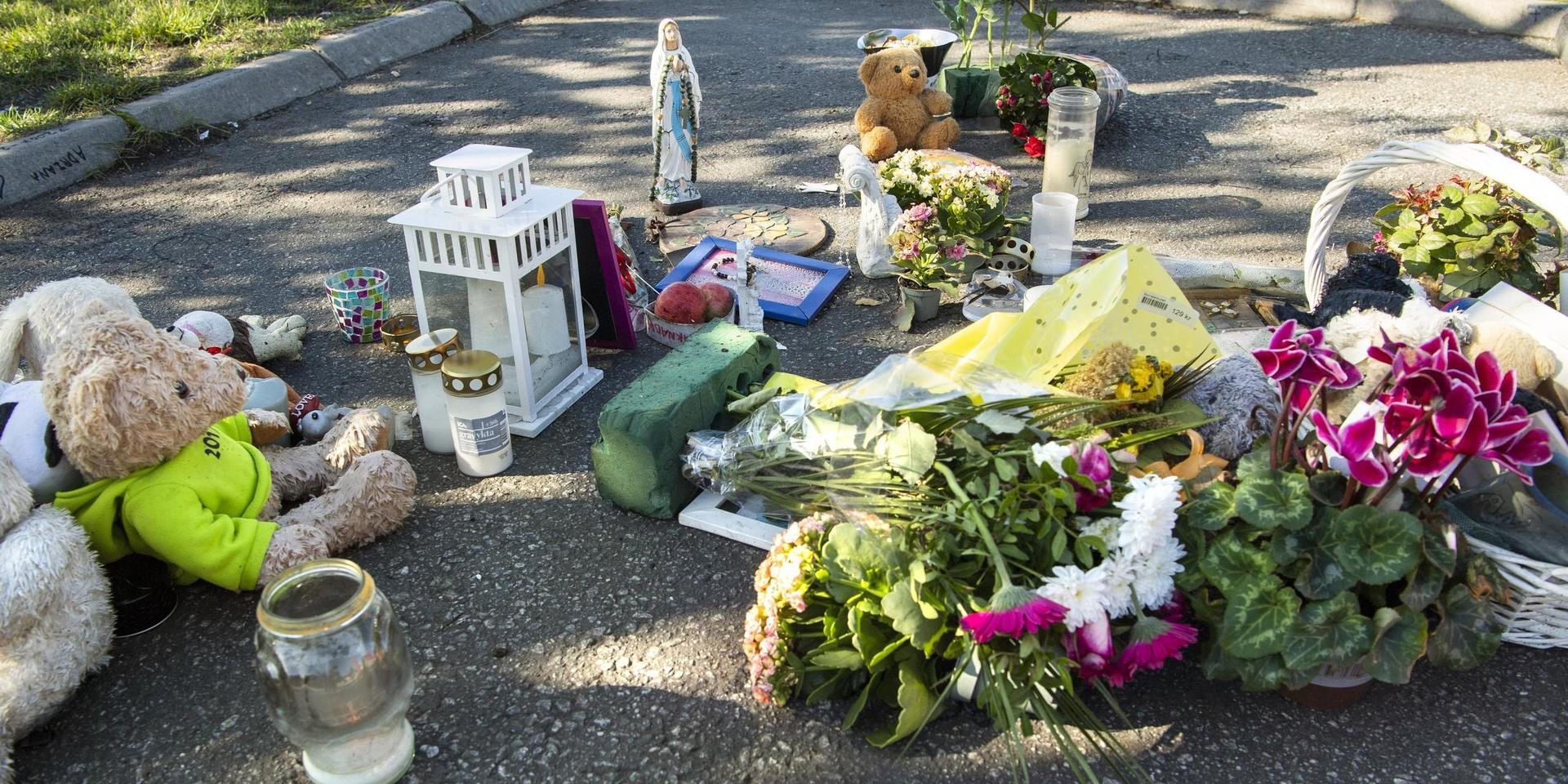 Blommor och nallar vid platsen där en tolvårig flicka sköts till döds i Botkyrka, tidigare i sommar..