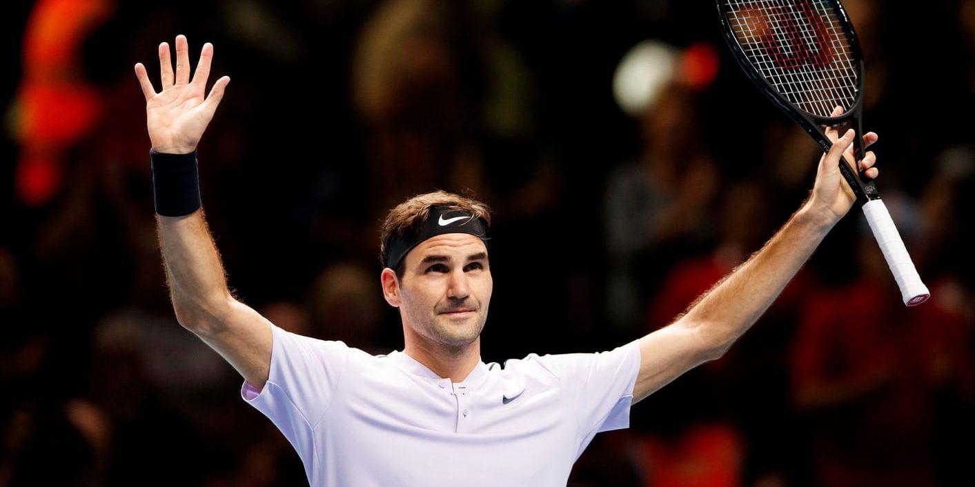 Roger Federer sträcker armarna i vädret efter att ha säkrat semifinalplatsen i ATP-slutspelet.