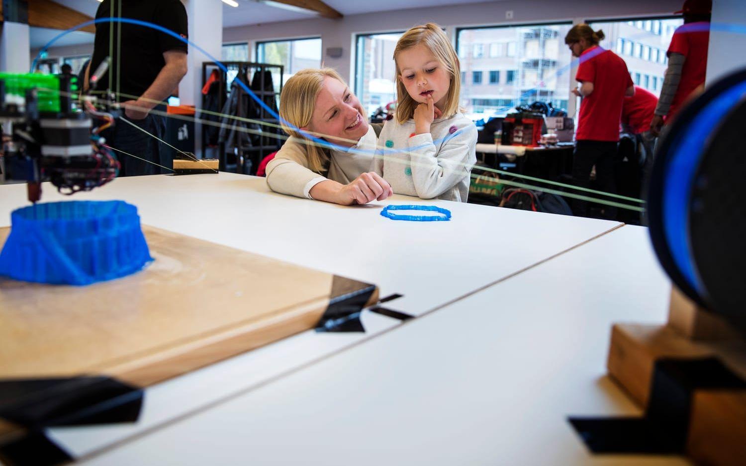 Anne Norén och dottern Emma, 6 år, tittade på 3D-printern som skrev ut ett torn hängandes i taket. Bild: Anders Ylander