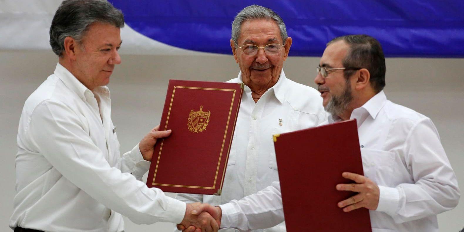 Colombias president Juan Manuel Santos (till vänster) och Farc-ledaren Timoleón Jiménez (till höger) skakar hand i samband med en ceremoni i Havanna, Kuba, efter det att båda parterna i juni i år undertecknat ett avtal om eldupphör och avväpning av rebellerna.