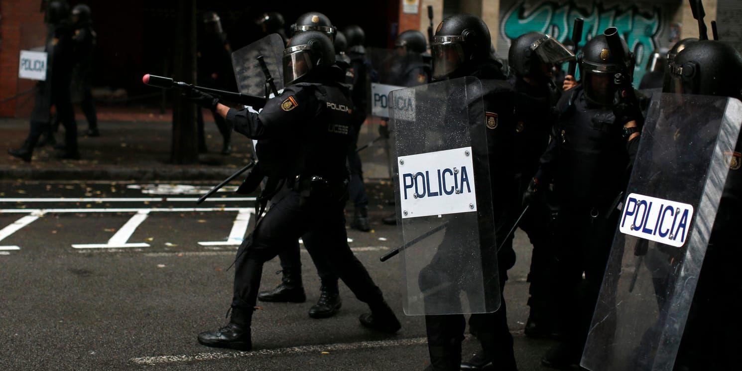 En polis riktar ett gummibollsgevär mot folkomröstningsanhängare i Barcelona.