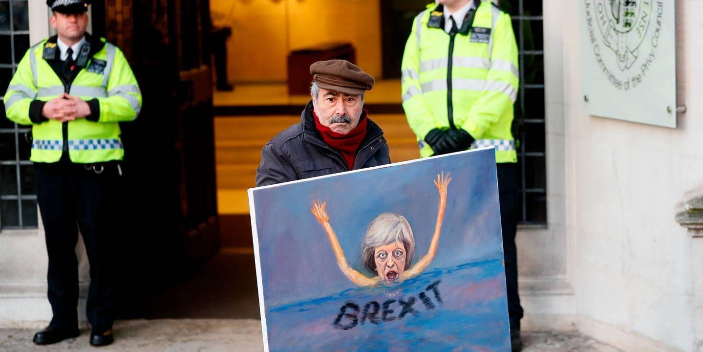 Konstnären Kaya Mar visar sin senaste målning av premiärminister Theresa May framför Högsta domstolen i London i dag.
