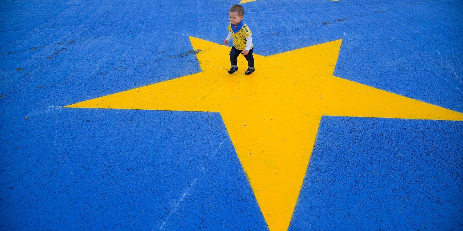 En rumänsk pojke vandrar på en målad EU-flagga i huvudstaden Bukarest. Rumänien är ordförandeland när EU behöver göra viktiga vägval under våren 2019. Arkivbild.