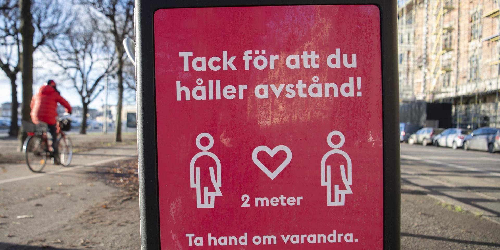En skylt på en soptunna på Strandvägen i centrala Stockholm uppmanar människor att hålla avstånd. Arkivbild.