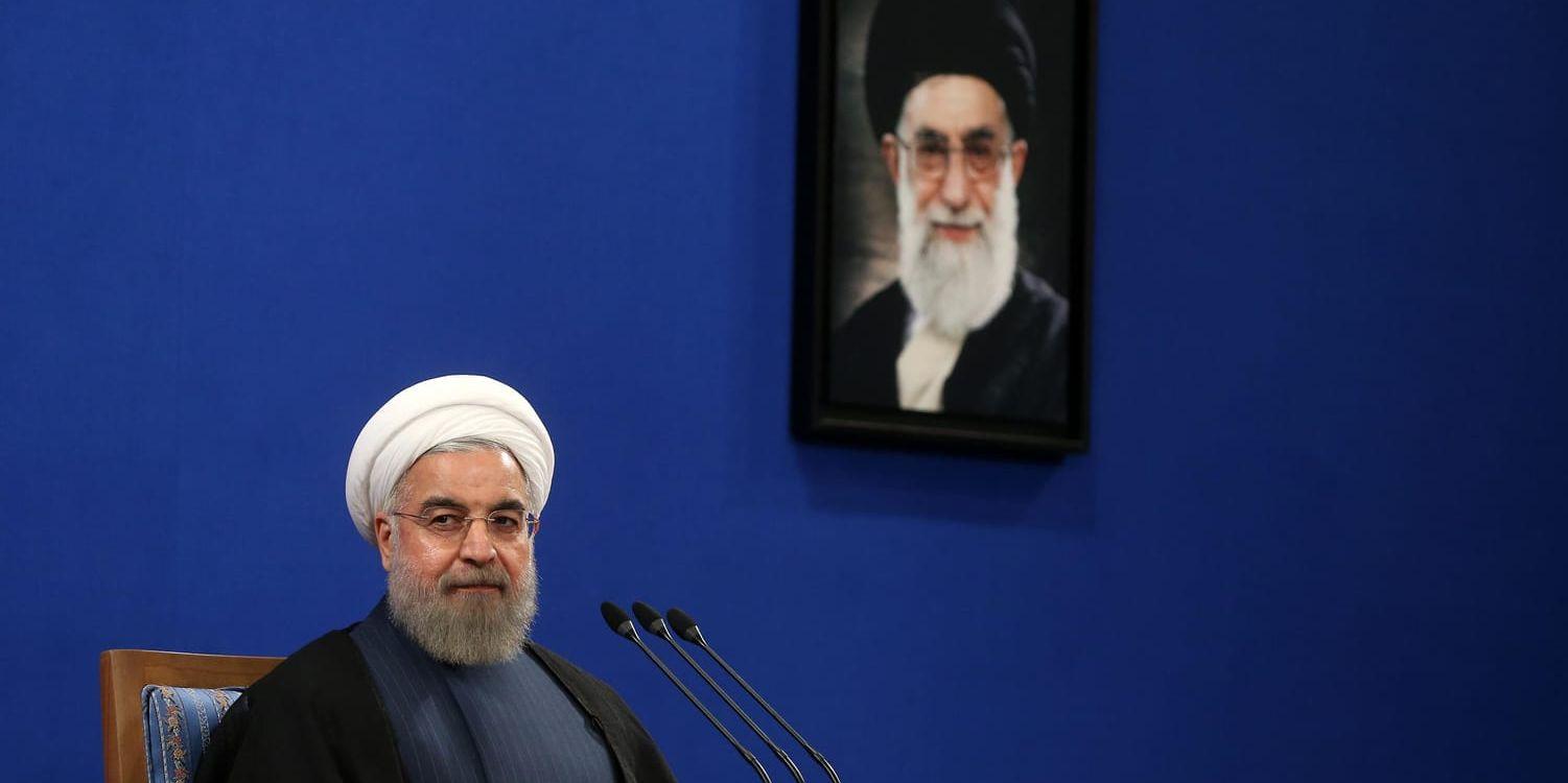 Irans president Hassan Rohani under en presskonferens i Teheran 2015. I bakgrunden hänger en bild på landets högste ledare, ayatolla Khamenei. Arkivbild.