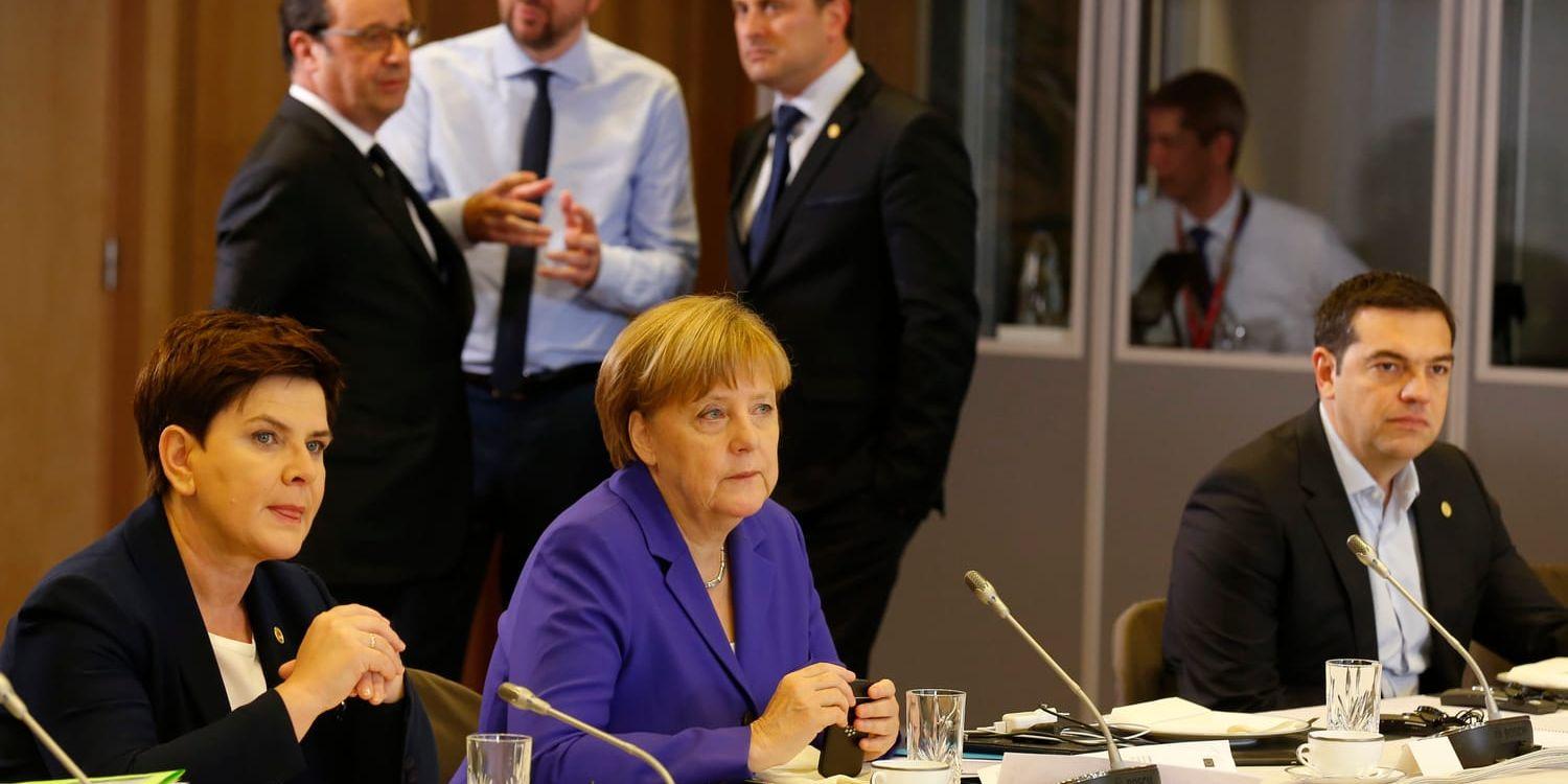 Belgiens premiärminister Charles Michel talar med Frankrikes president Francois Hollande och Luxemburgs premiärminister Xavier Bettel vid en rundabordskonferens under EU-toppmötet i Bryssel. I förgrunden bland andra Tysklands förbundskansler Angela Merkel.
