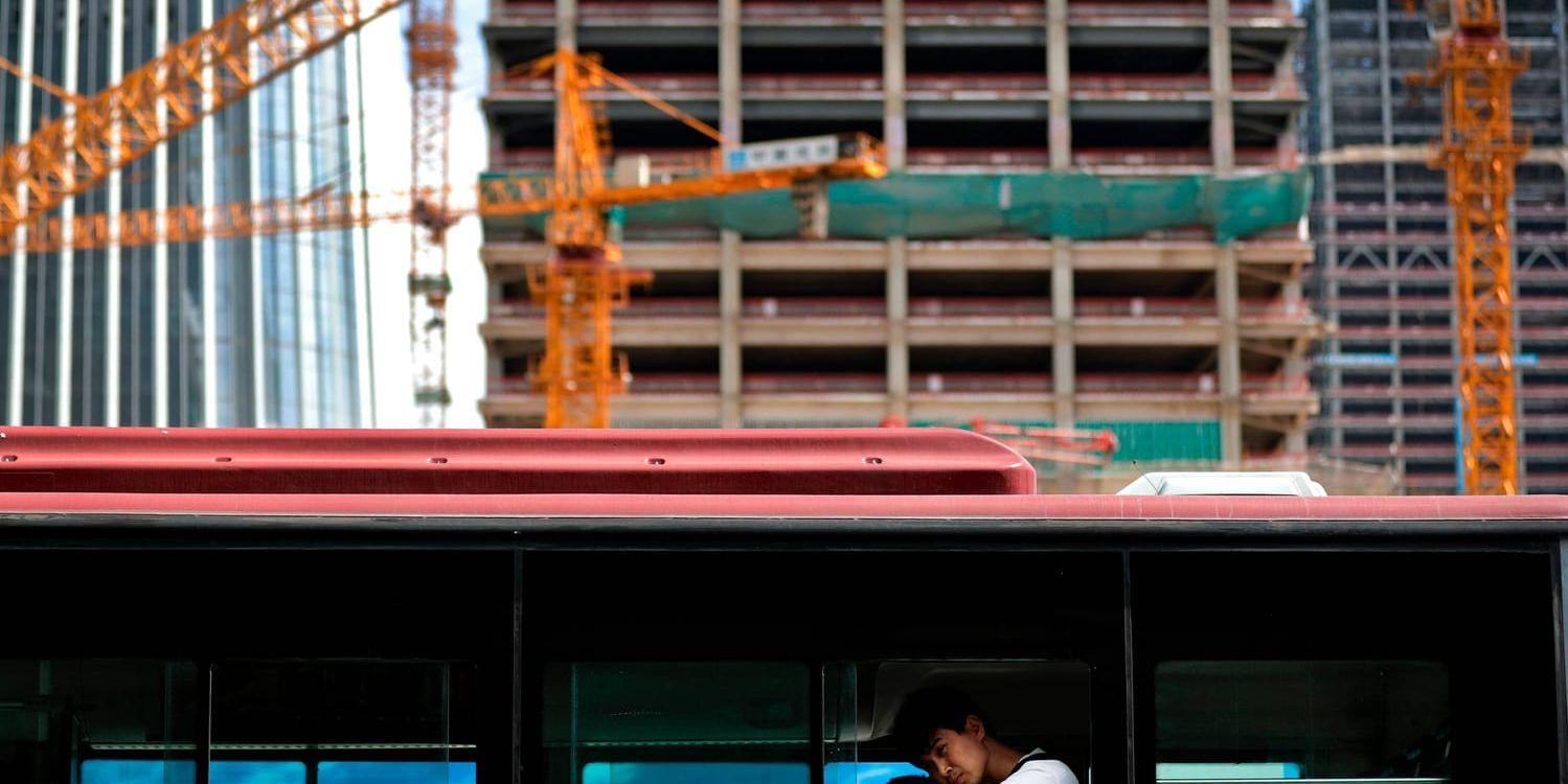 En buss passerar en byggarbetsplats i Peking. Arkivbild.