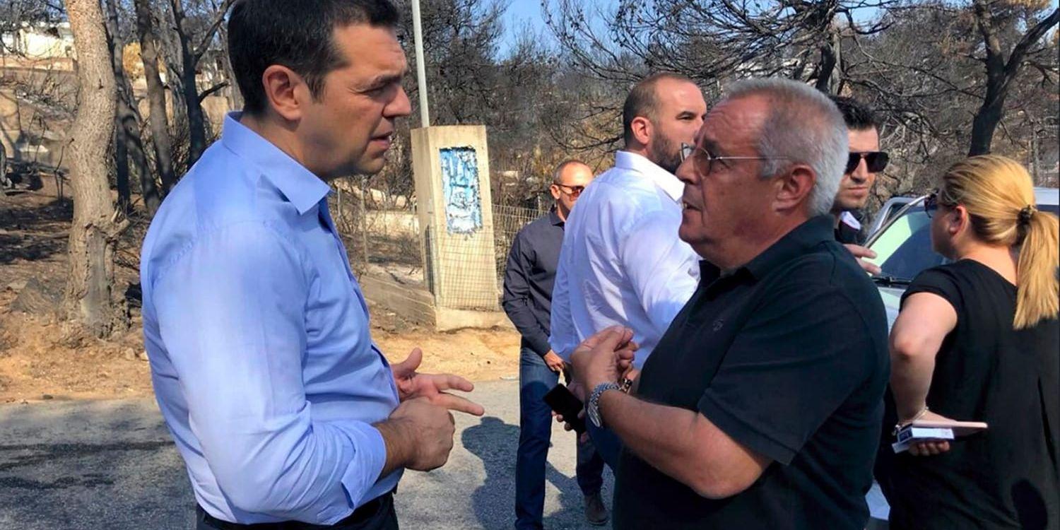 Premiärminister Alexis Tsipras (till vänster) under ett besök i den eldhärjade kuststaden Mati. Arkivbild.