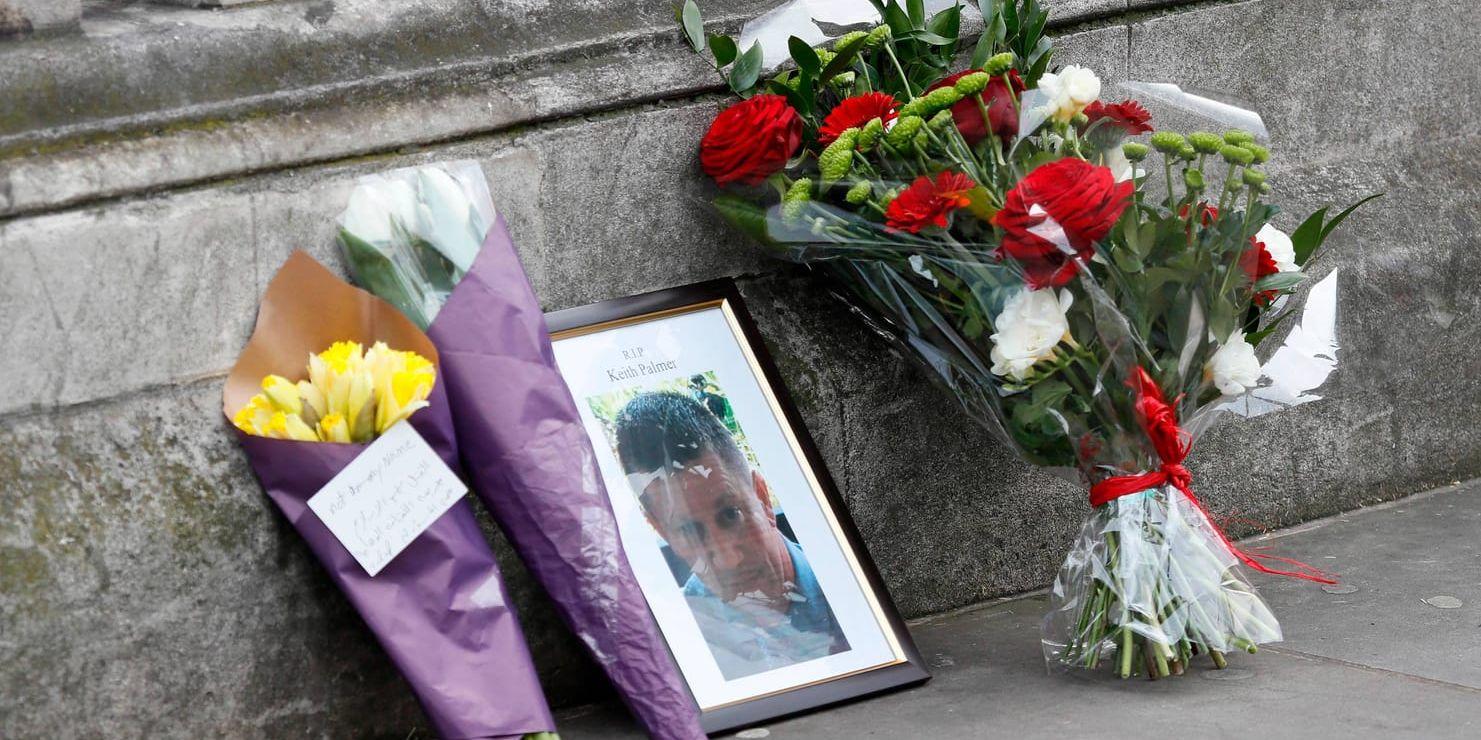 Blommor och ett fotografi av polisen Keith Palmer som dödades i attacken vid parlamentsområdet i London.