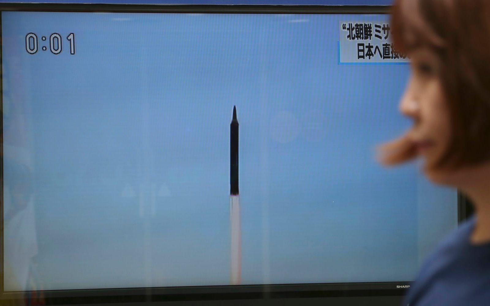 En kvinna går förbi en tv som visar den senaste avfyrningen av ballistiska missiler av Nordkorea. FOTO: Koji Sasahara/AP

