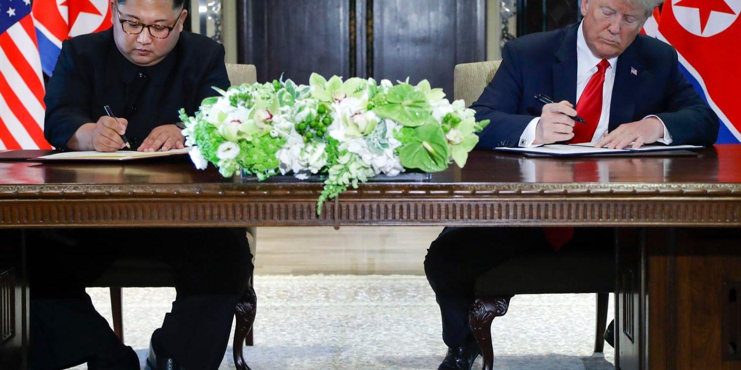 Kim Jong-Un och president Donald Trump signerar ett dokument i Singapore.