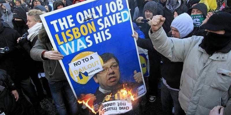 Vem räddas? Irändare visar sitt kraftiga missnöje med räddningspaketet. Här bränns ett plakat med premiärminister Brian Cowens bild.