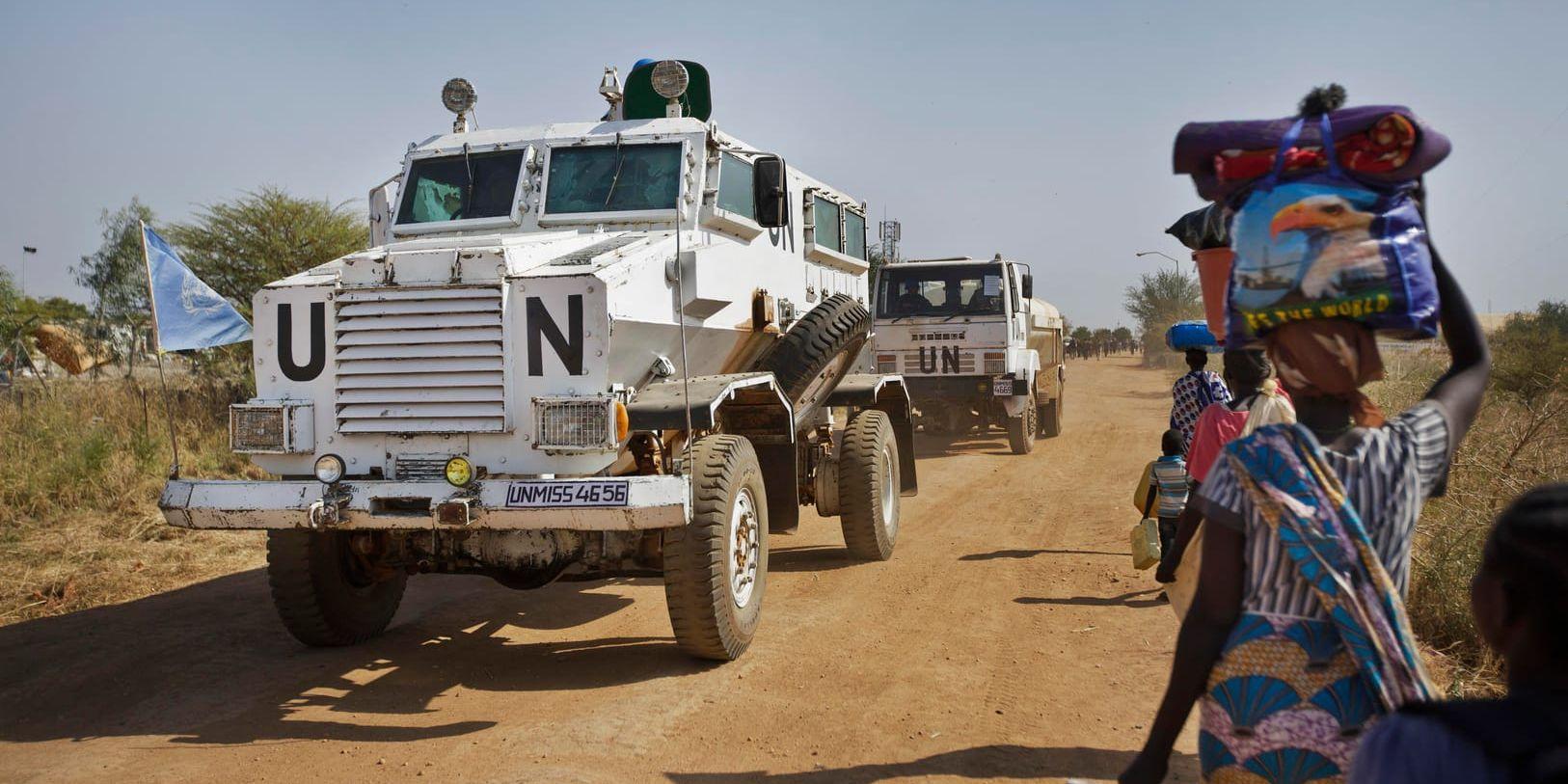 FN-fordon passerar människor på väg mot ett flyktingläger i staden Malakal i Sydsudan. Människorna på bilden har inget att göra med artikeln.