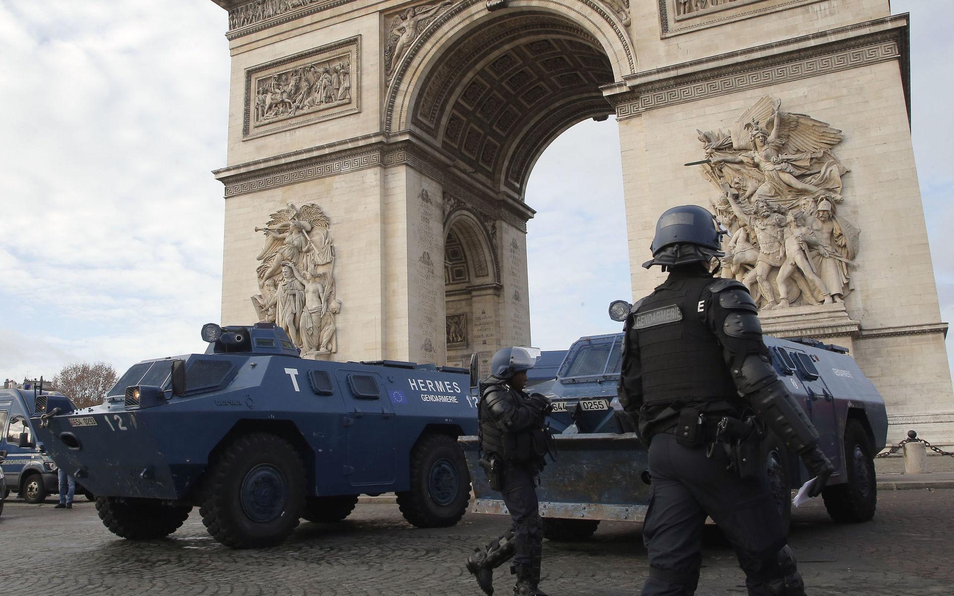 Armerade polisfordon patrullerar längst med Triumpfbågen i Paris. 