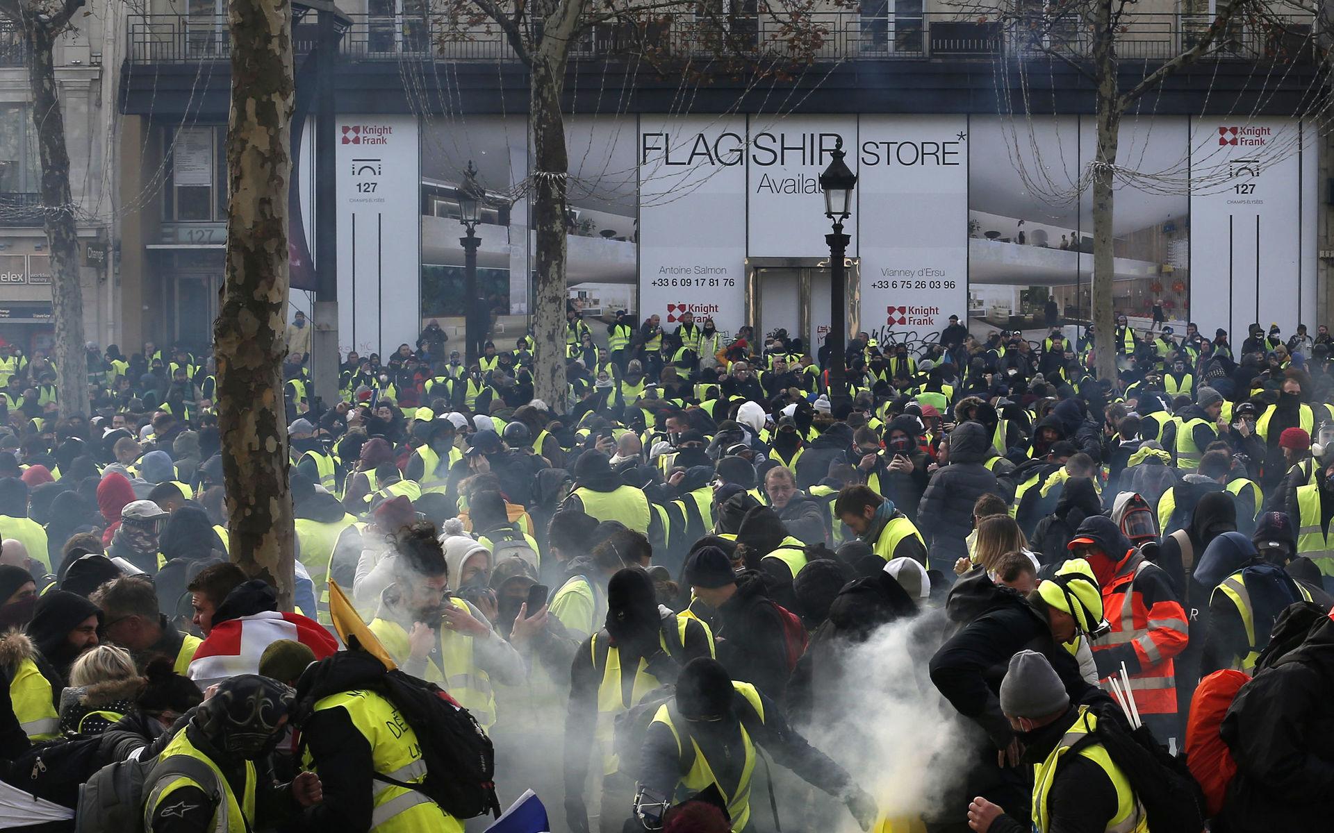 Demonstranter i gula västar samlas kring Champs-Elysees. 