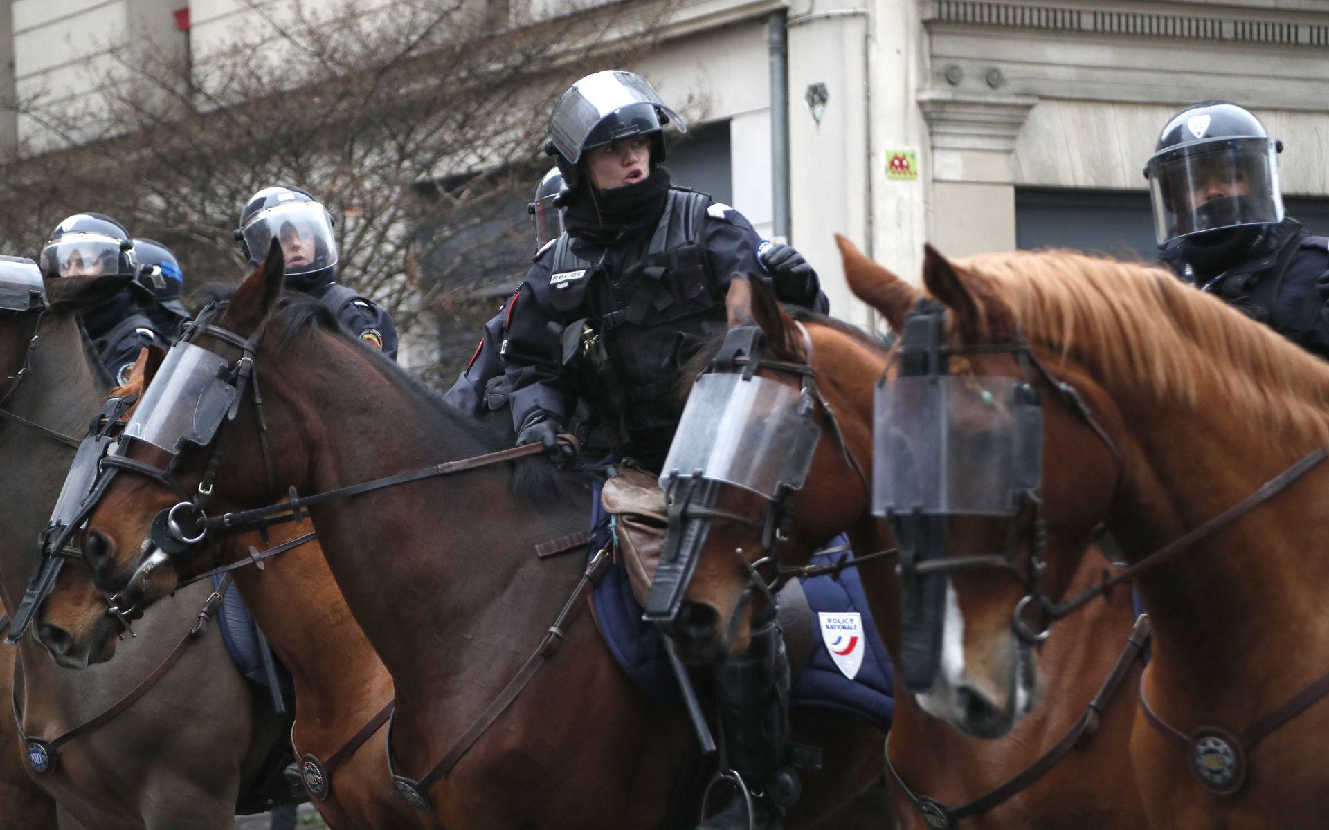 Ridande poliser intar sina positioner inför sammandrabbningar med demonstranterna i Paris. 