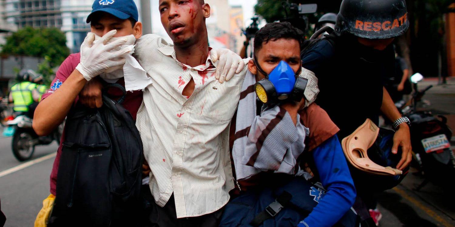 En man som skadats i samband med de våldsamma protesterna i Venezuela på torsdagen får hjälp.