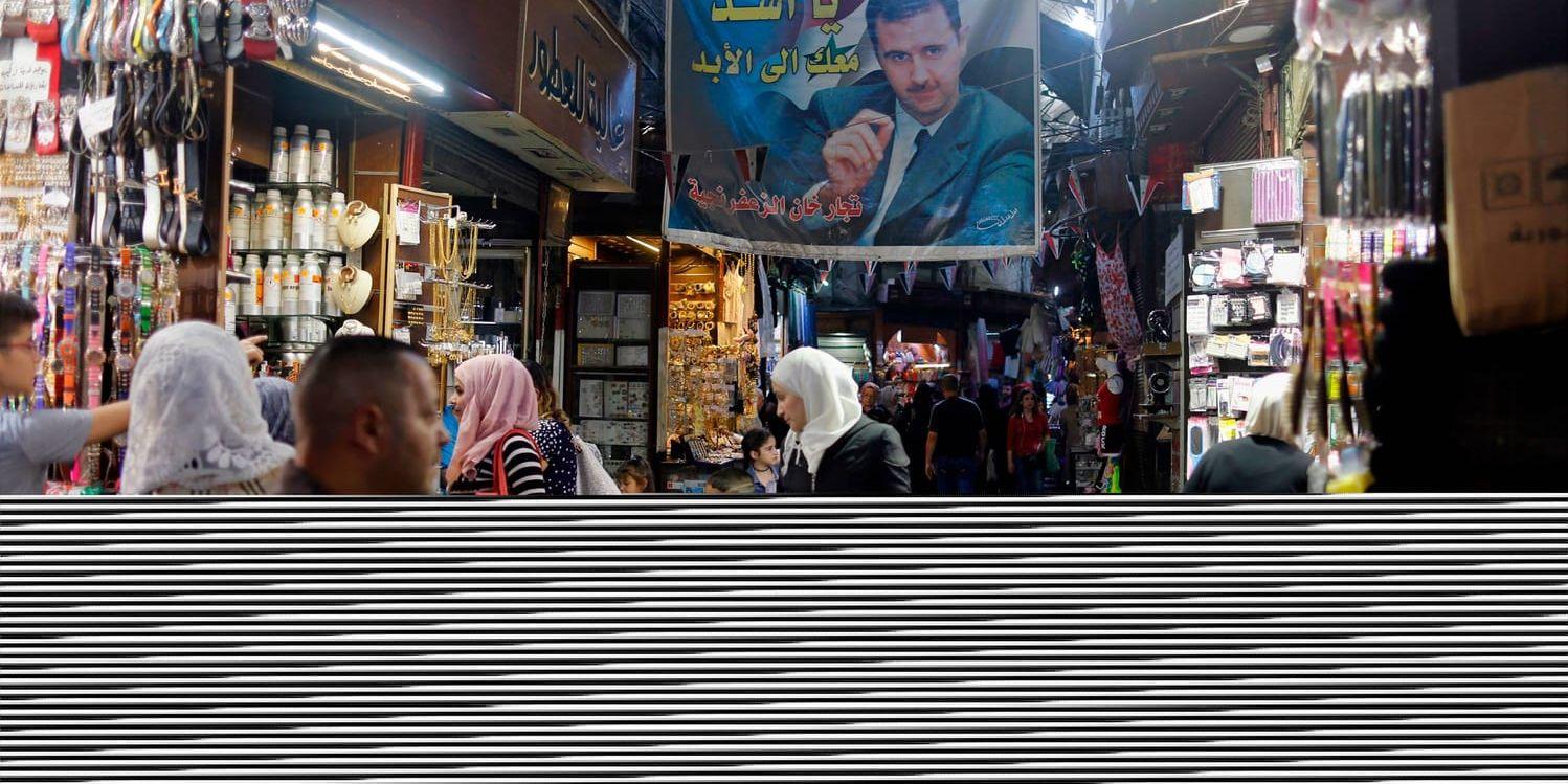 Syriens president Bashar al-Assad visar sig sällan utanför huvudstaden Damaskus. I dag har han gjort ett undantag, i staden Hama. Arkivbilden med propaganda för presidenten togs i basaren i Damaskus i maj.