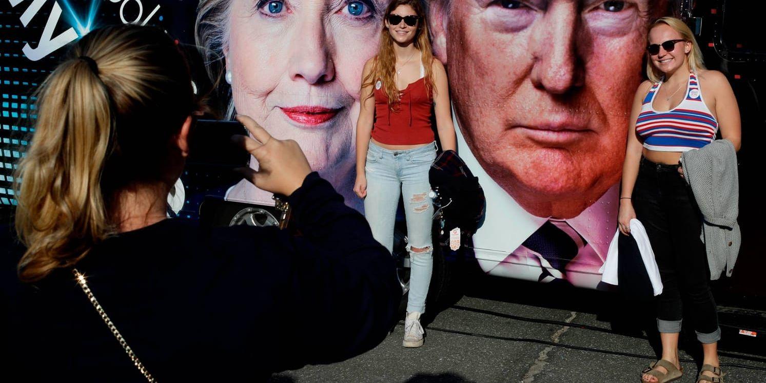 Studenter poserar framför bilder av presidentkandidaterna Hillary Clinton och Donald Trump.