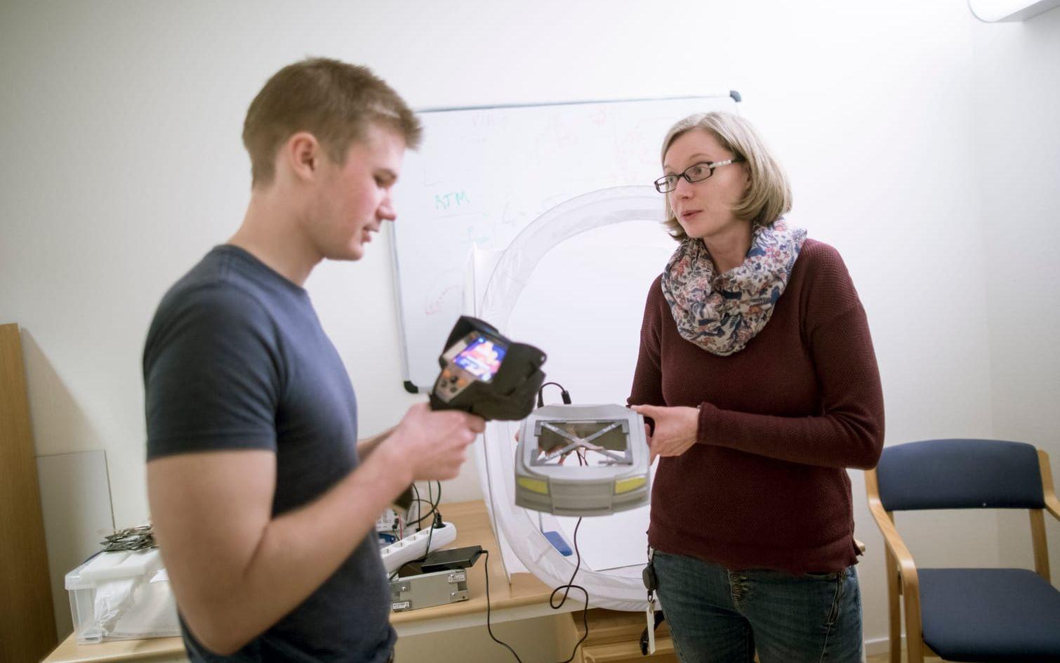 Angelika Bachinger och labbingenjören Peter Hellström undersöker en modell som visar principen bakom deras forskning kring mjuknande motorhuvar.