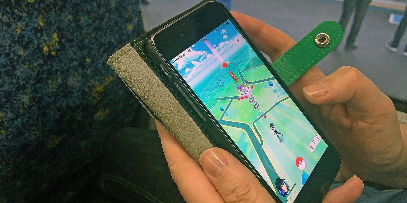 En person spelar succéspelet Pokémon Go på pendeltåget.