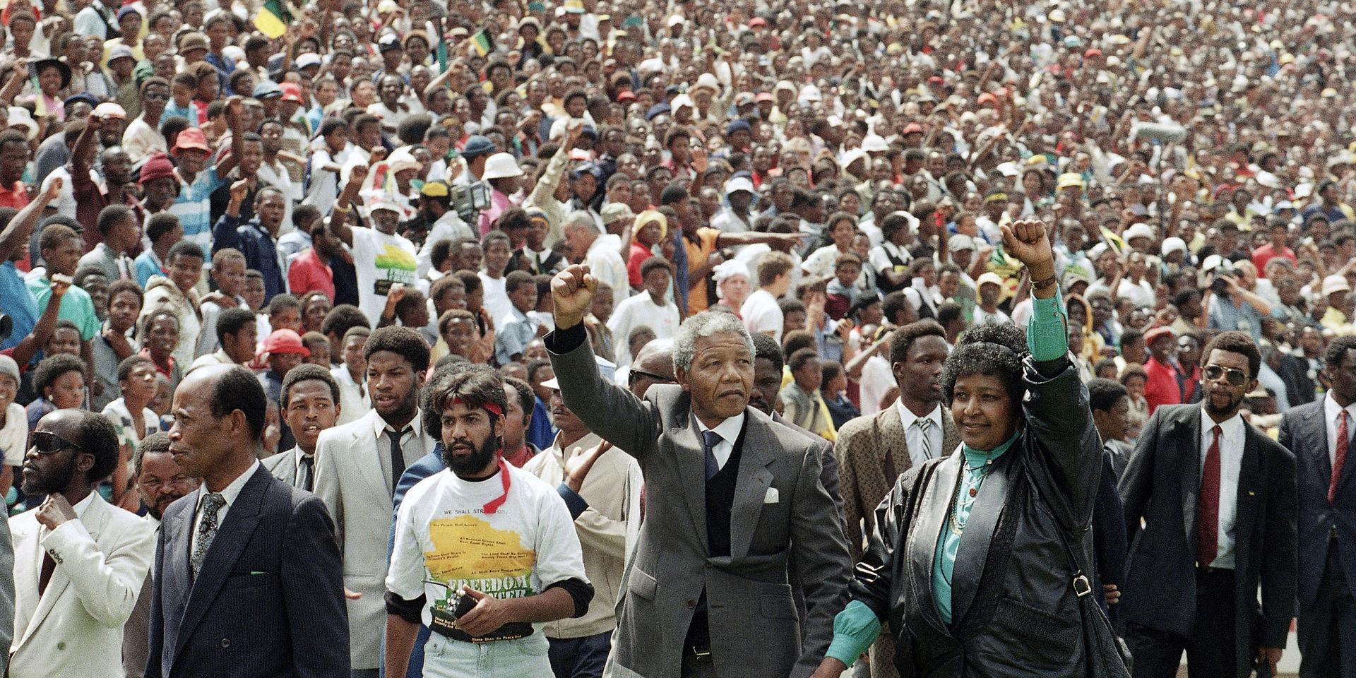 Frigivningen. I kortet, som är taget den 13 februari 1990 anländer Nelson Mandela och hans hustru Winnie, till höger, med höjda knutna nävar till ett ANC rally i Soweto två dagar efter hans frigivelse från fängelset i Kapstaden, där han suttit fängslad i 27 år. 