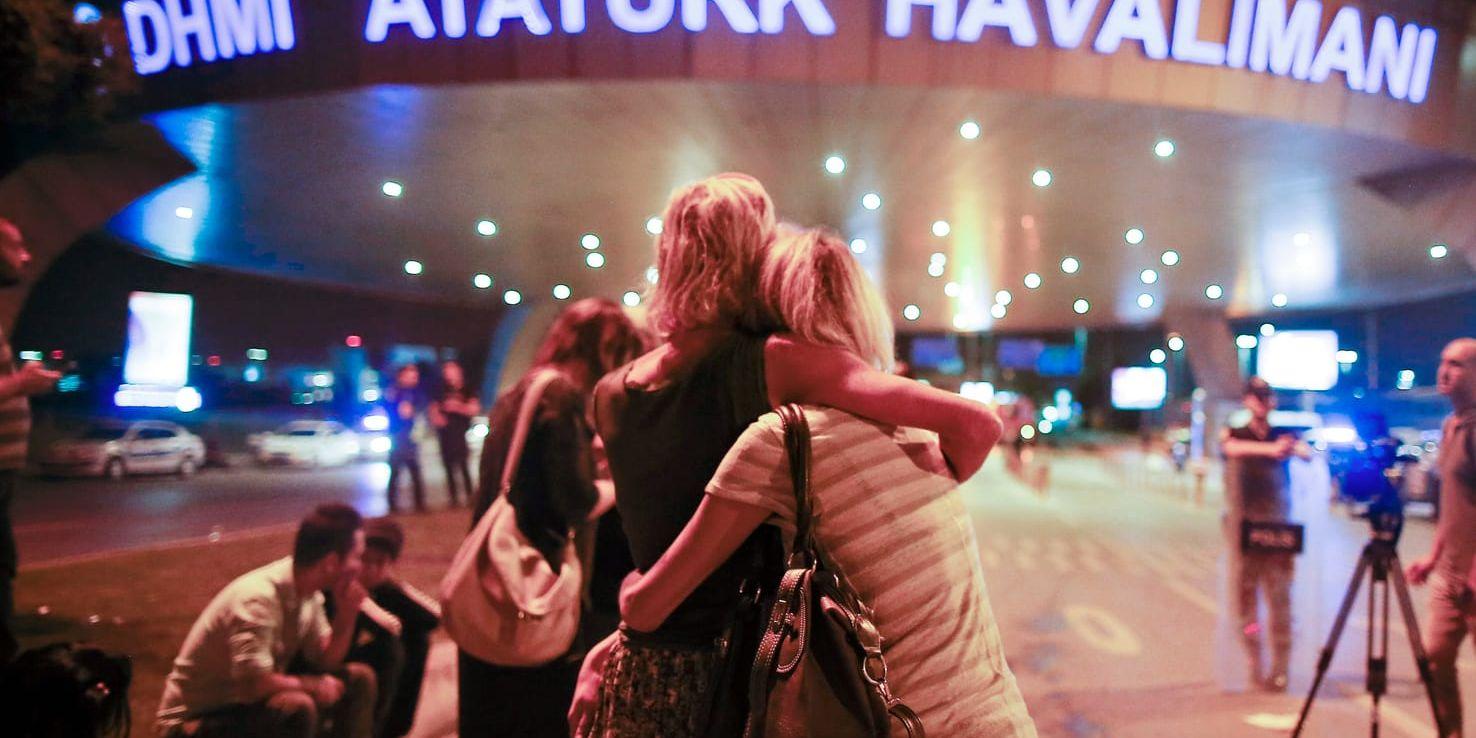 Passagerare kramar om varandra utanför Atatürkflygplatsen i Istanbul efter dådet.
