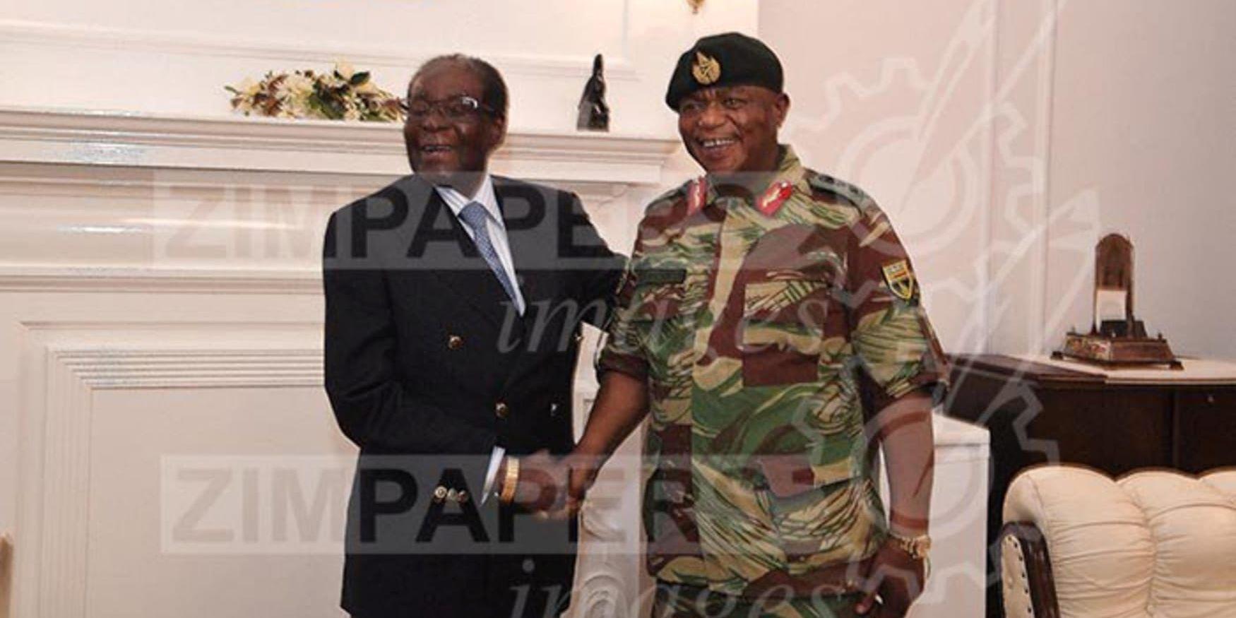 Zimbabwes president Robert Mugabe till vänster poserar leende tillsammans med landets arméchef Constantino Chiwenga Bilden är tagen i samband med förhandlingarna den 16 november.
