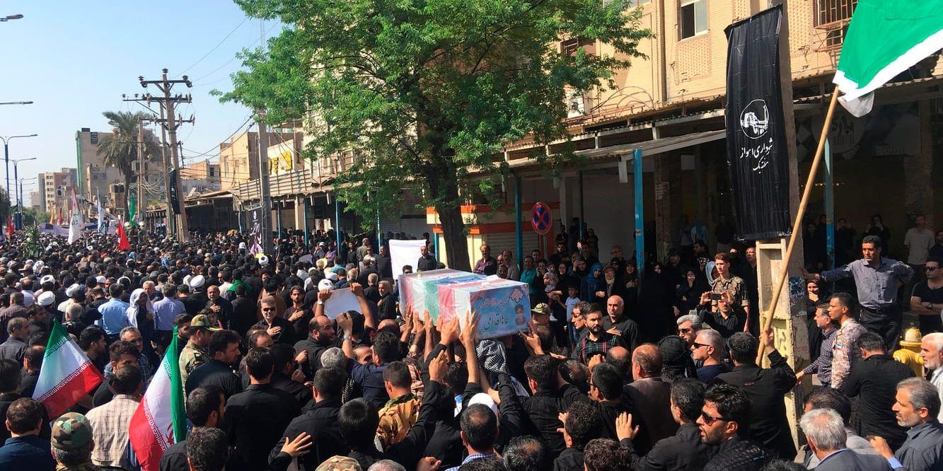Sörjande bär en kista vid massbegravningen av attentatets offer i Ahvaz.