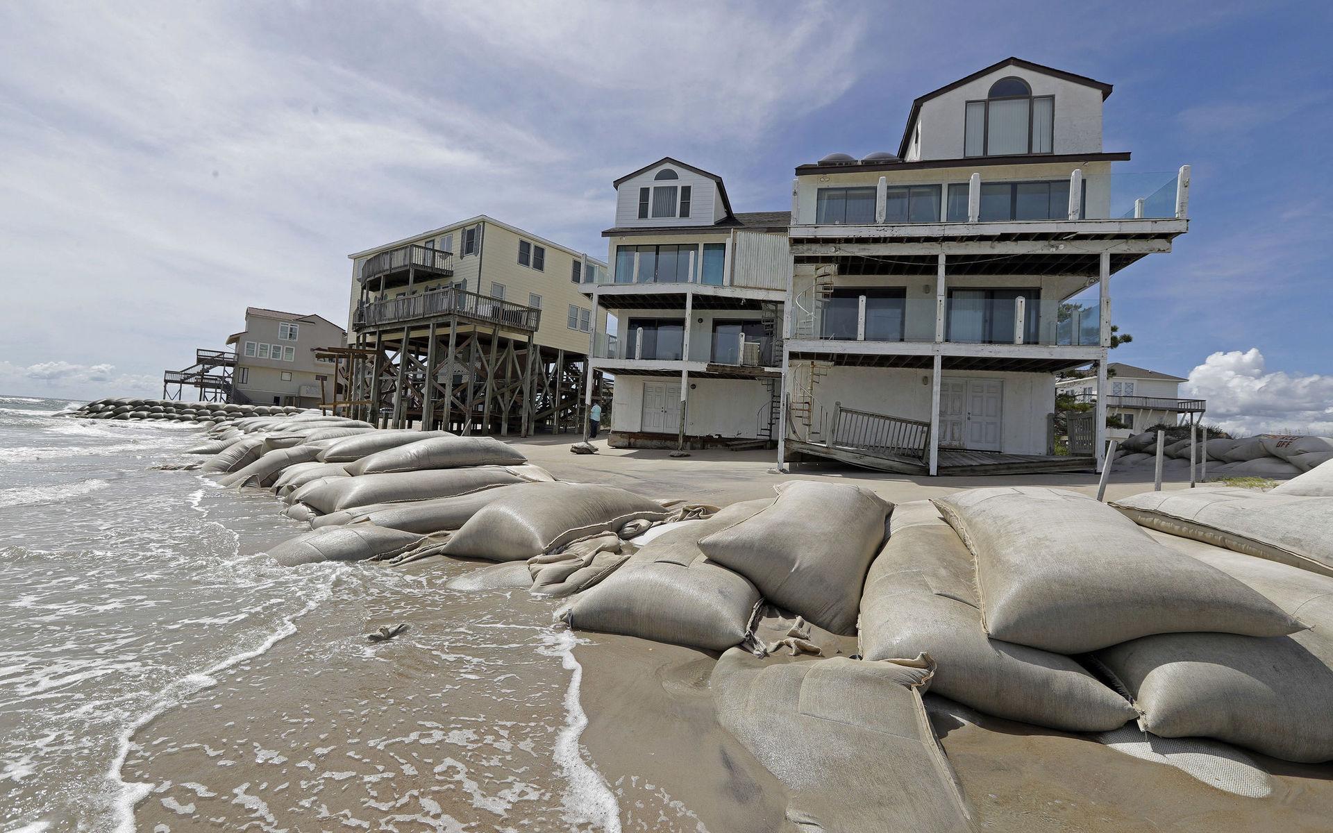 Bostadshus vid stranden i North Topsail Beach, North Carolina har omringats av sandsäckar för att skyddas mot orkanen. 