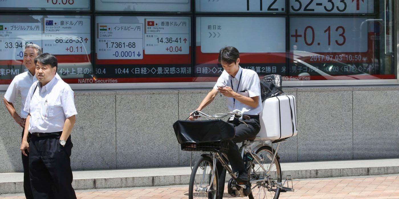 Vilka värden varar? Japaner funderar framför en skärm med växlingskurser i Tokyo. Arkivbild.