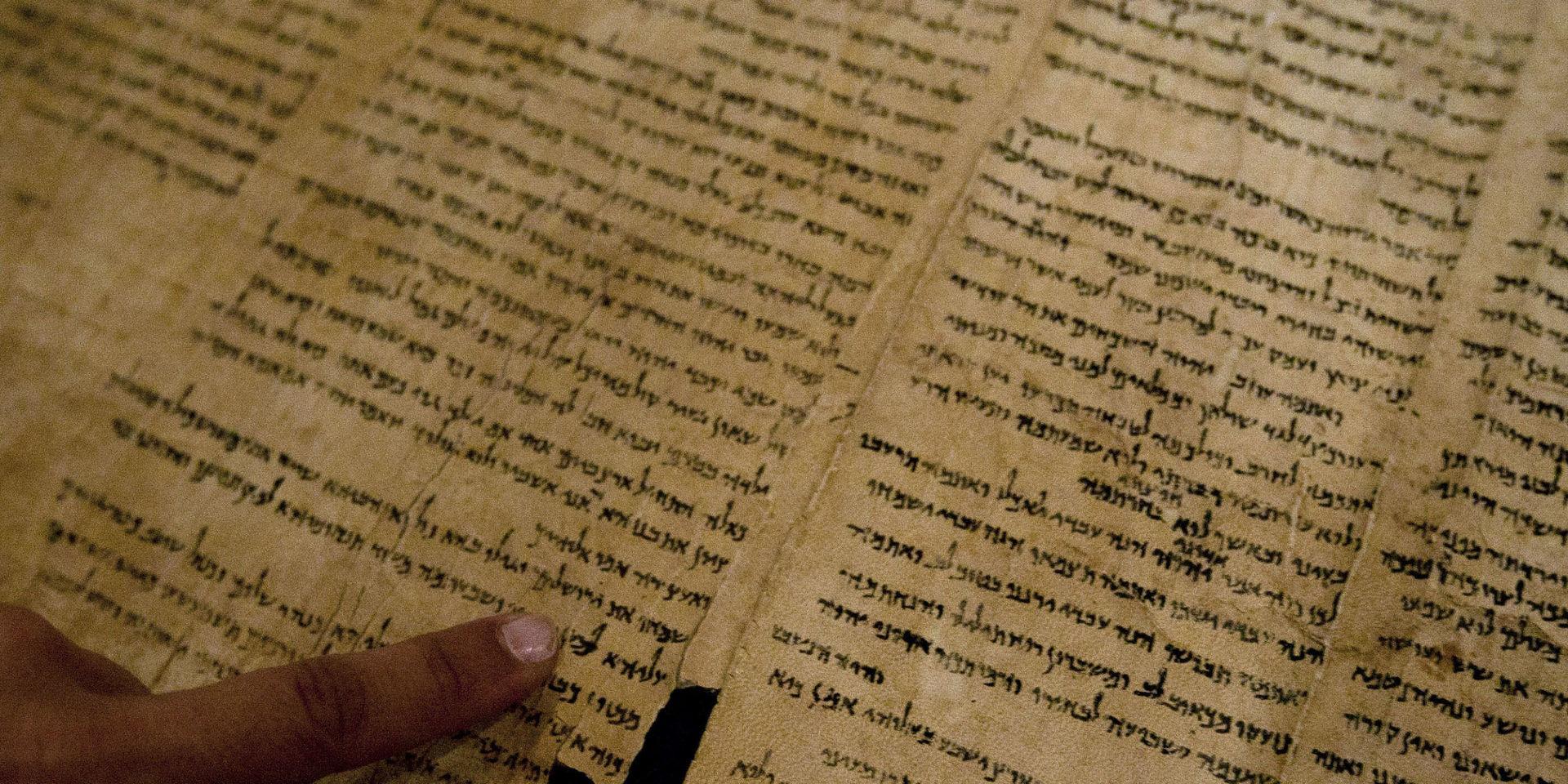 Delar av Dödahavsrullarna är i väsentligt bättre skick än fragmenten. Här pekar en israelisk museianställd på ordet 'Jerusalem' i en av texterna, som bland annat innehåller de tidigaste utgåvorna av den hebreiska bibeln som har hittats. Arkivbild.