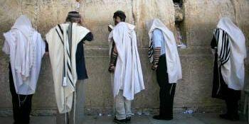 <b>Klagomuren.</b> Judiska män i bön vid den heliga platsen.