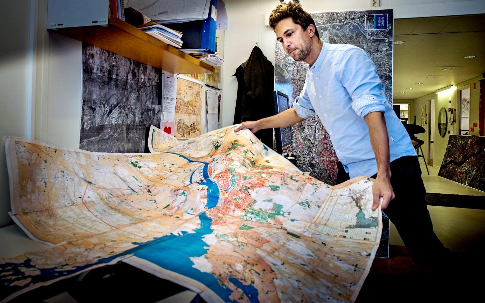 Lukas Memborn, arkitekt som har sett framtiden genom att blicka bakåt, visar upp sina kartor och historiska stadsplaner på Stadsbyggnadskontoret. Bild: Lisa Thanner