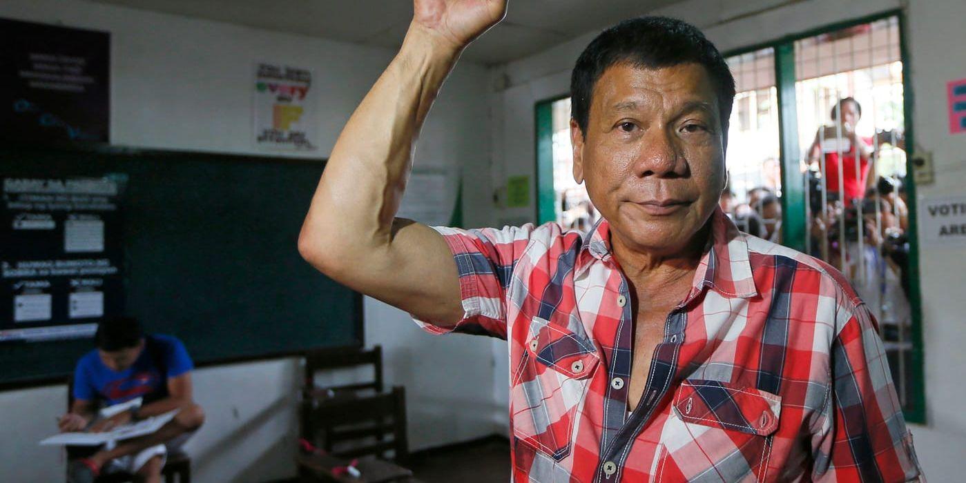 Rodrigo Duterte höjer näven mot luften efter att ha röstat i en skola i hemstaden Davao, där han styrt som borgmästare i över 20 år. Arkivbild.