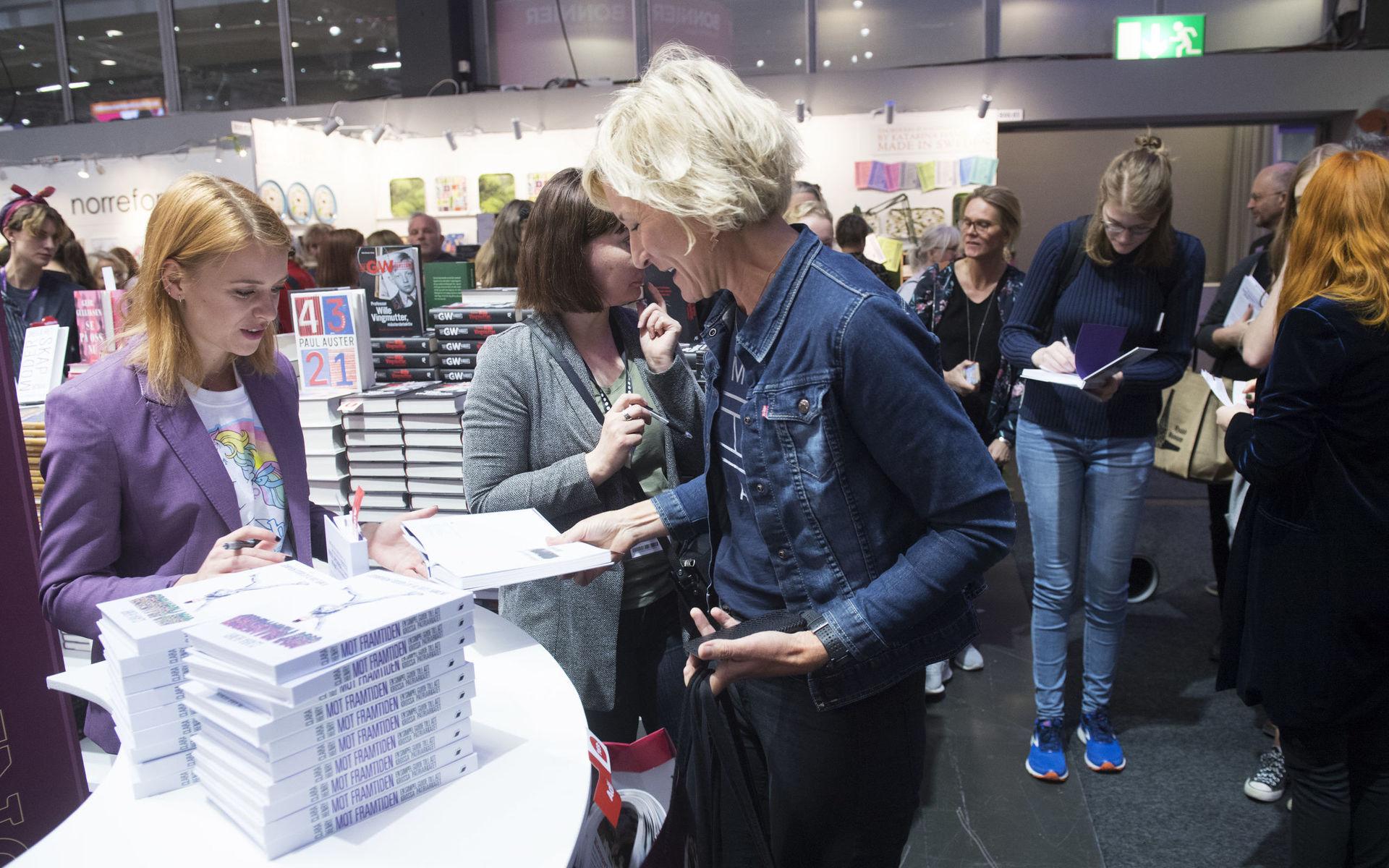 Clara Henry signerar böcker under Bokmässan i Göteborg. 