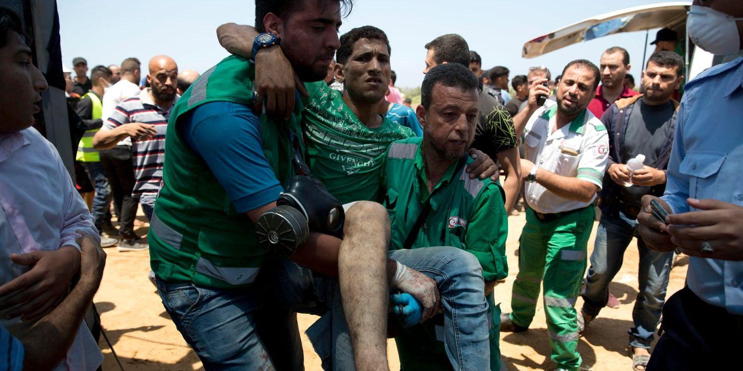 En skadad palestinier tas om hand av sjukvårdare under protester nära Bait Lahiya, Gazaremsan.