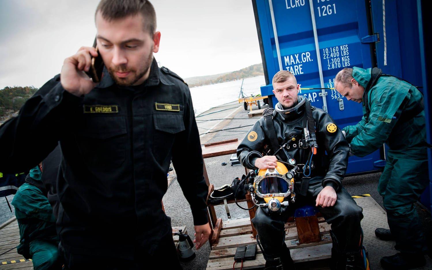 Modris Karlsons från lettlands räddningstjänst får hjälp att sätta på sig dykutrustningen av Lars Werner som jobbar i den svenska marinen.