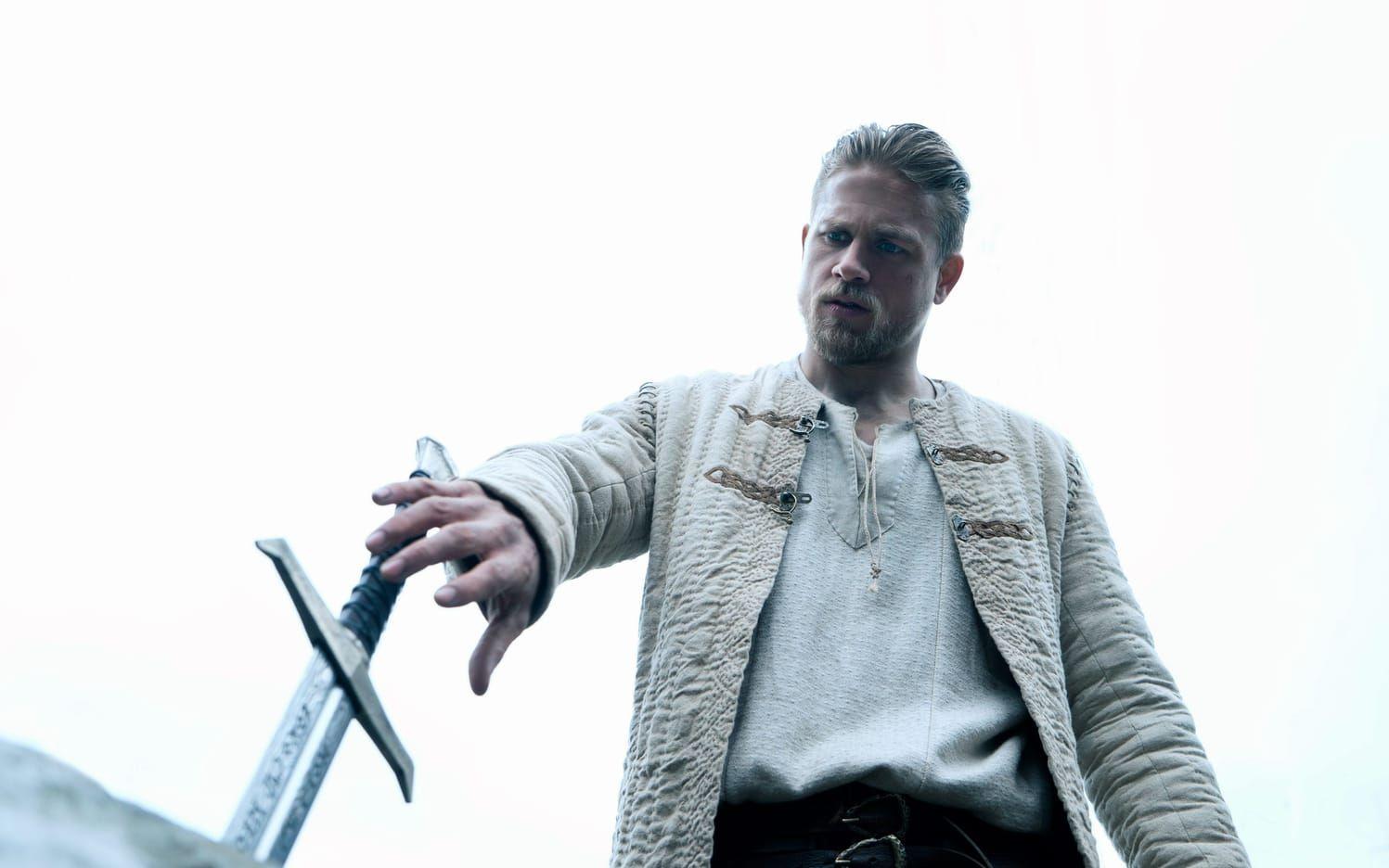 Kung Arthur (Charlie Hunnam) rycker svärdet ur stenen. Pressbild: SF.