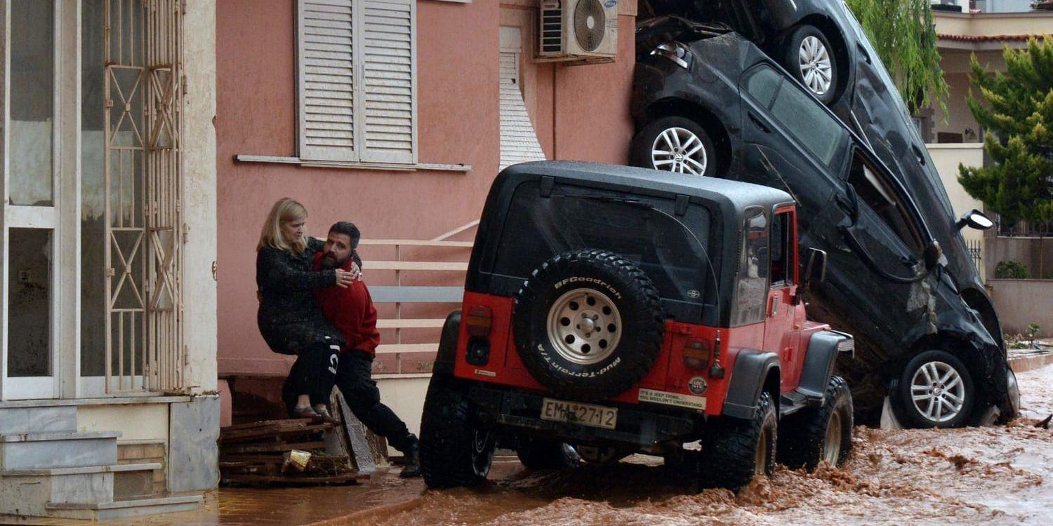En kvinna får hjälp i samband med översvämningarna i Mandra nordväst om Aten.