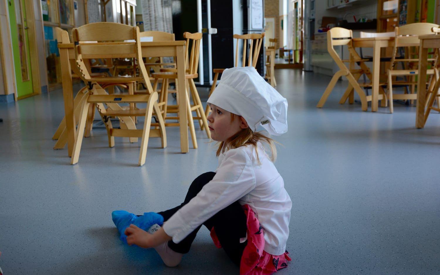 Stella Daltegen sätter på sig tossor innan hon går in i skolköket. Bild: Karina Hansson