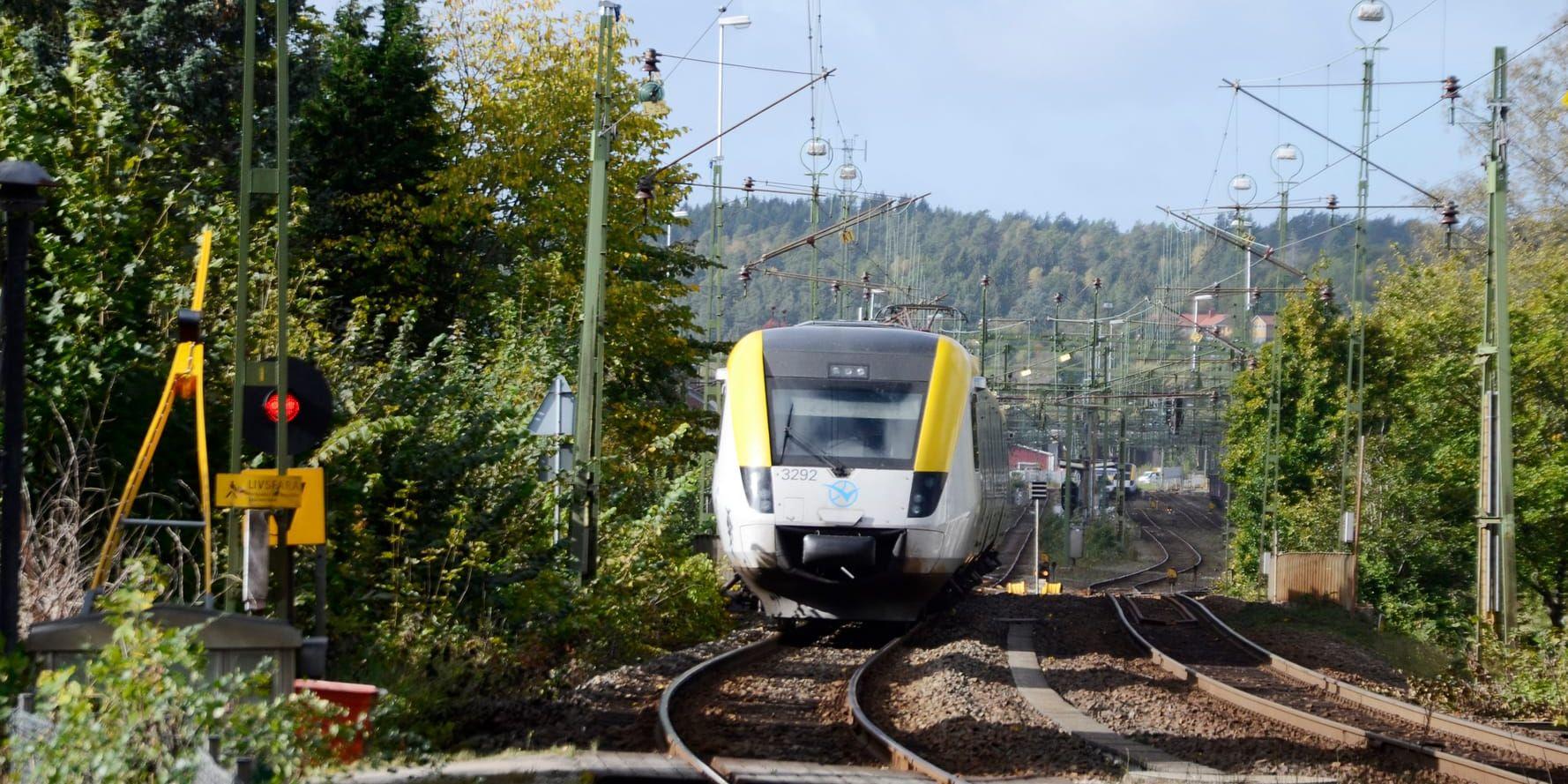 Tåg vid järnvägsövergången och tunneln vid Kyrkogårdsgatan i Uddevalla räls tåg Västtrafik Bohusbanan järnväg järnvägskorsning bommar 