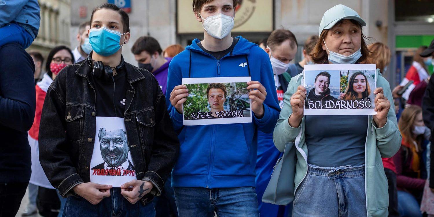 Demonstranter i Polen håller upp bilder på Belarus auktoritäre president Aleksandr Lukasjenko (till vänster), regimkritikern Roman Protasevitj och juridikstudenten Sofia Sapega.