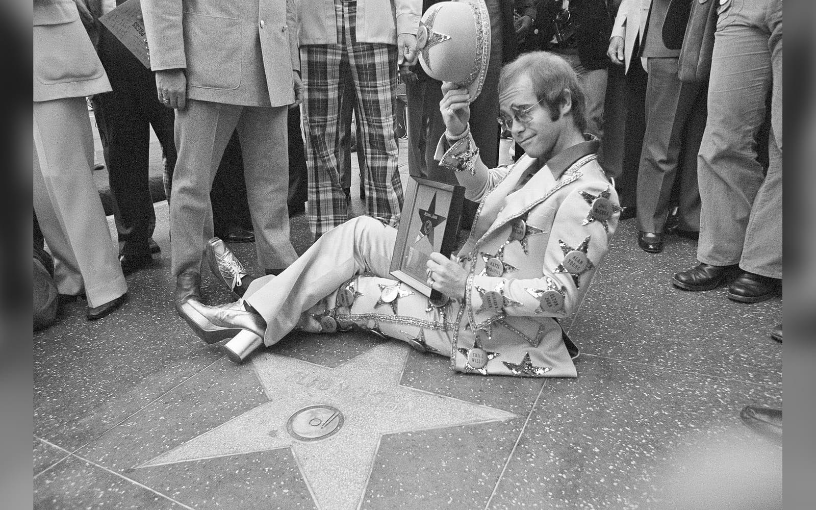 1975: Elton John poserar med sin sprillans nya stjärna på Hollywood Walk of Fame. Foto: TT