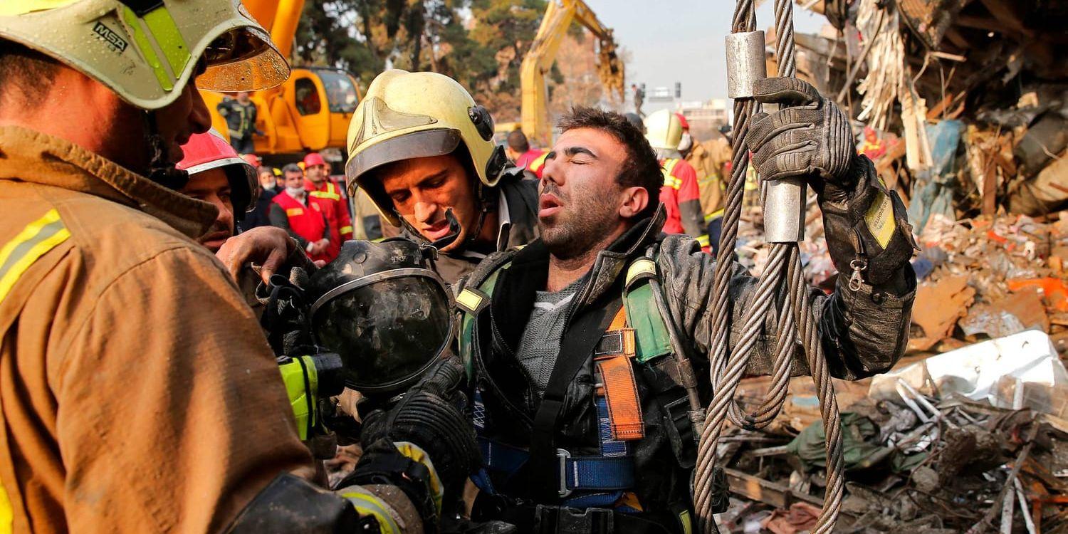 Iranska brandmän under uppröjning efter raset i Teheran.