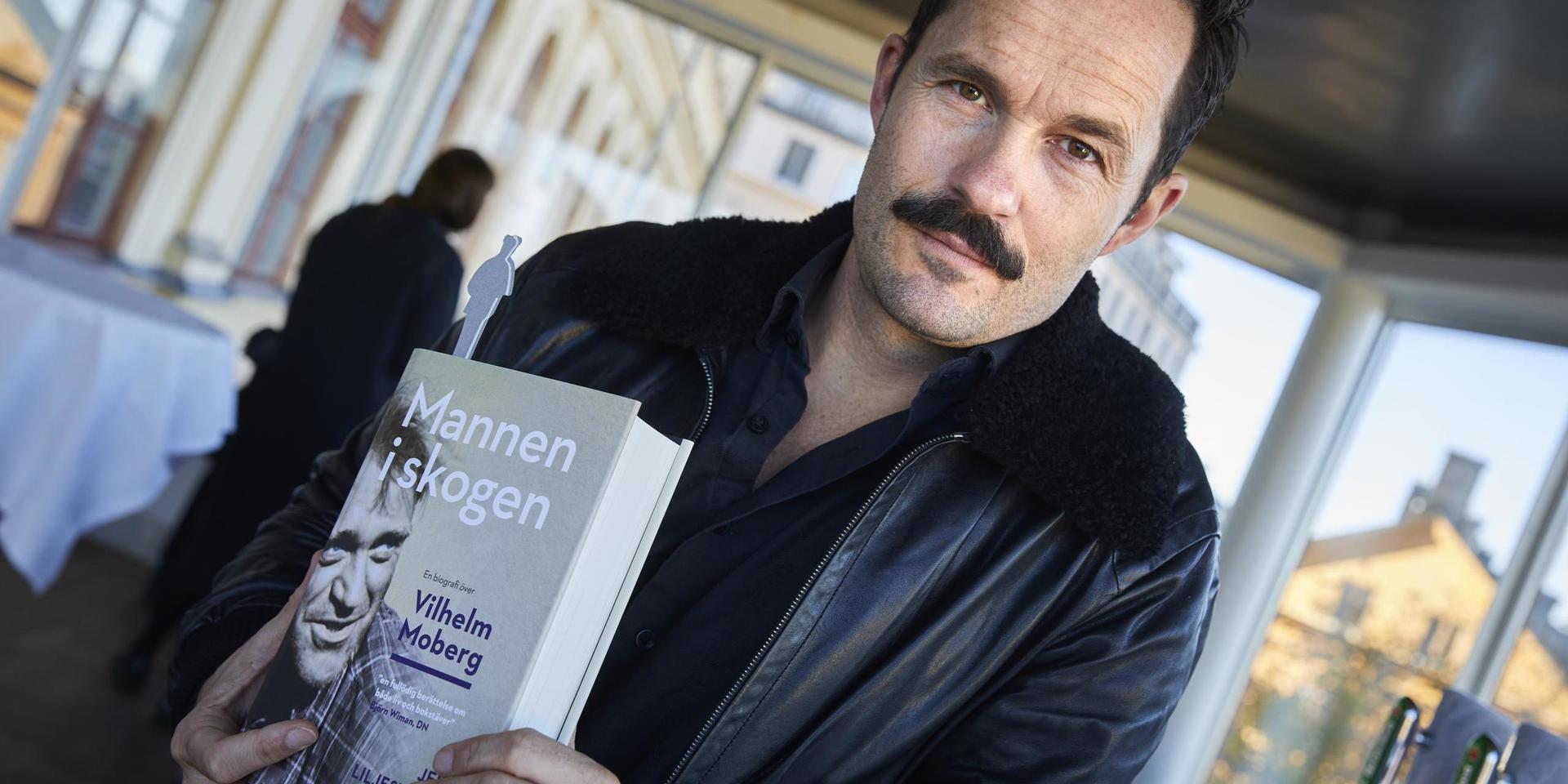 Expressens f.d. biträdande kulturchef, Jens Liljestrand, håller upp ett exemplar av sin biografi över Vilhelm Moberg. 