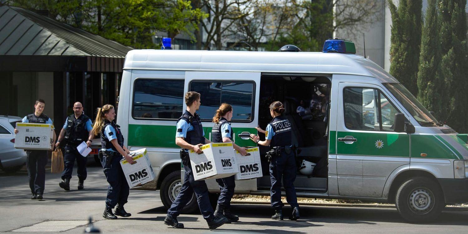 Polis kånkar lådor med beslagtaget material utanför Porsches lokaler i Stuttgart på onsdagen.