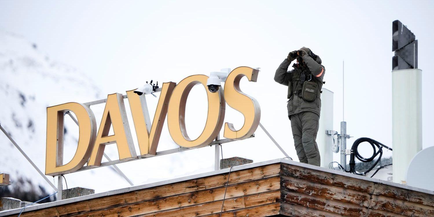 En polis spejar ut från ett hotelltak i Davos, måndagen den 16 januari 2023. Den årliga kongressen Världsekonomiskt forum där världsledare samlas i Schweiz under fyra dagar börjar på måndagen. 
