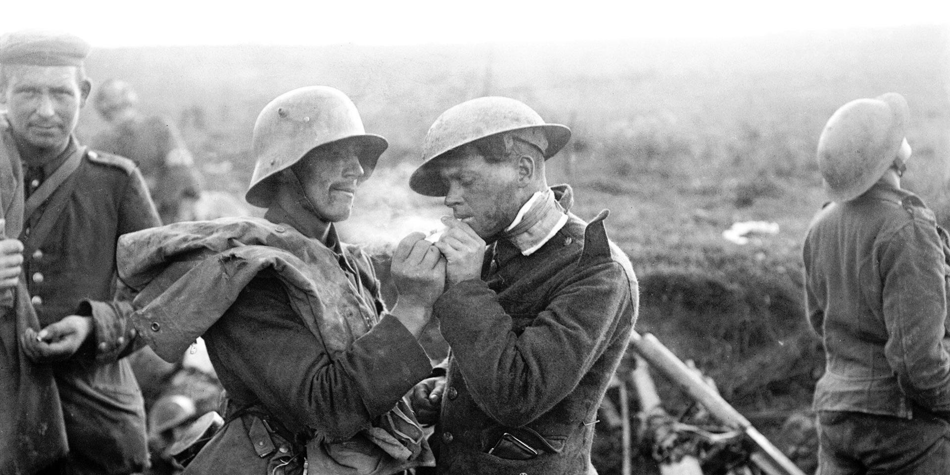 En tysk krigsfånge tänder en cigarett åt en engelsk soldat. Bilden är tagen under första världskriget.