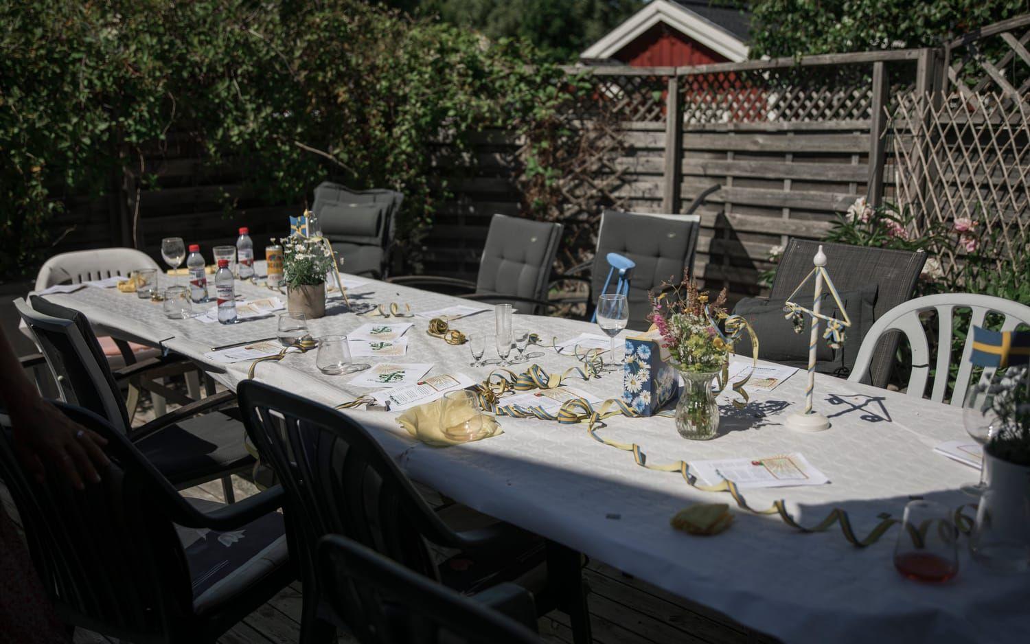 På bordet står blomstervaser, Sverigeflaggor och halvdruckna snapsglas. Här har sällskapet på 19 personer precis avnjutit en midsommarlunch med en twist.